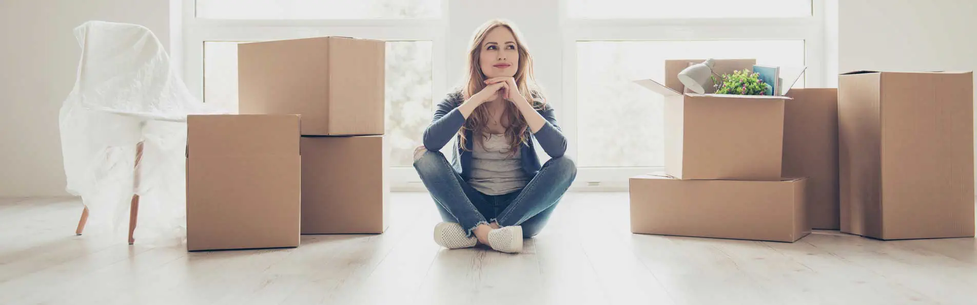 Femme assise au milieu de ses cartons avant un déménagement